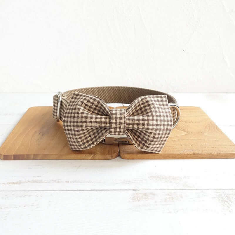 Plaid Elegance Dog Collar & Leash Set on wooden surface, featuring a classic plaid pattern and a stylish bow tie.