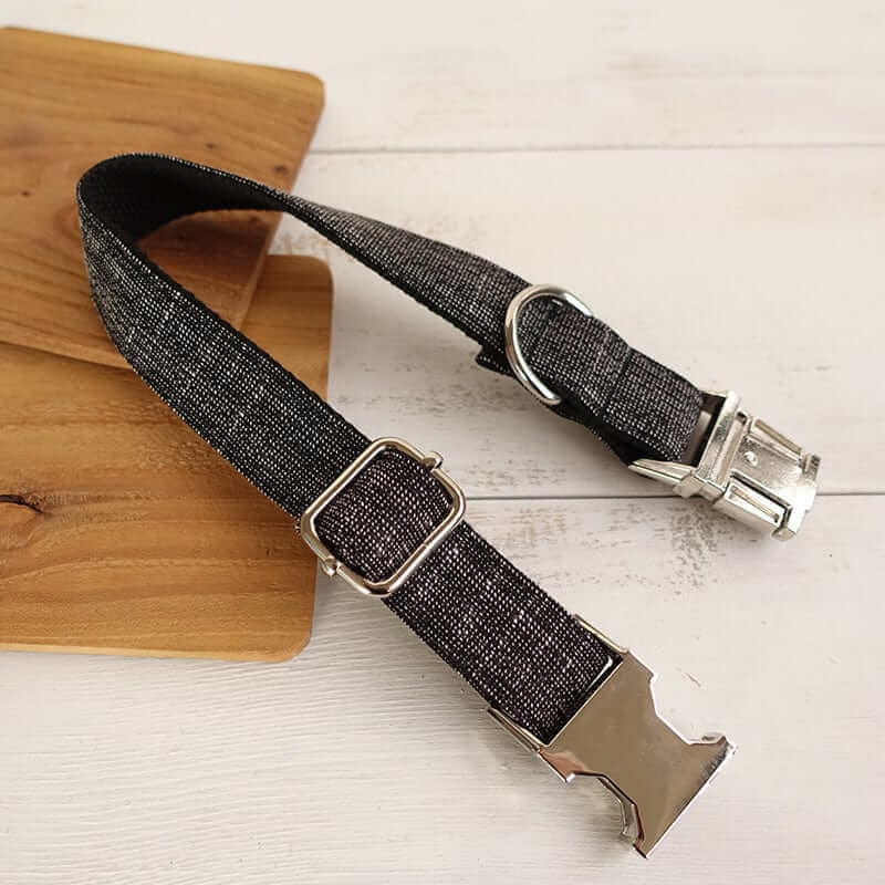 The Black Suit Dog Collar & Leash showcasing a sleek black design with a metal buckle and loop, perfect for pets.